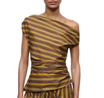 A woman wears the Staud Phare Top, an off-the-shoulder, short-sleeve brown and yellow striped top with a fitted, gathered waist, paired with matching bottoms.