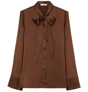 The CO Scarf Blouse is a brown, long-sleeve charmeuse top featuring a button-down front and a statement bow tie at the neck.