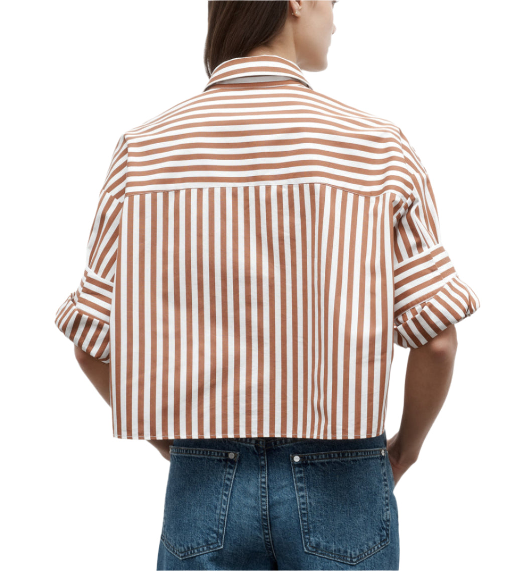 Model wears the TWP Next Ex Stripe Shirt, a brown and white vertically striped, cropped button-down with rolled sleeves and a boxy silhouette, paired with blue jeans and shown from the back.