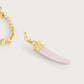 The Anabel Aram Milos Stone Horn Charm features a gold chain necklace with a pink stone horn pendant capped in gold, inspired by Mediterranean designs.