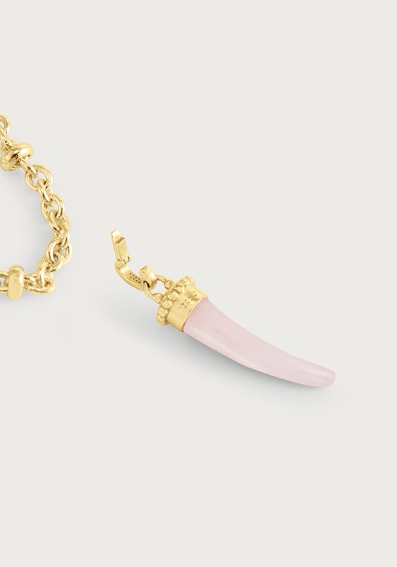 The Anabel Aram Milos Stone Horn Charm features a gold chain necklace with a pink stone horn pendant capped in gold, inspired by Mediterranean designs.