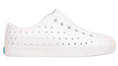 The Kids’ Jefferson Shoes by Native Shoes are lightweight, water-friendly slip-ons featuring multiple ventilation holes and a textured toe and sole, shown here on a plain white background.