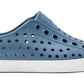 The Kids’ Jefferson Shoes by Native Shoes feature a blue slip-on design with circular ventilation holes, a white toe cap, and a white sole, shown here in side profile. Lightweight and water-friendly, they’re perfect for kids’ everyday adventures.