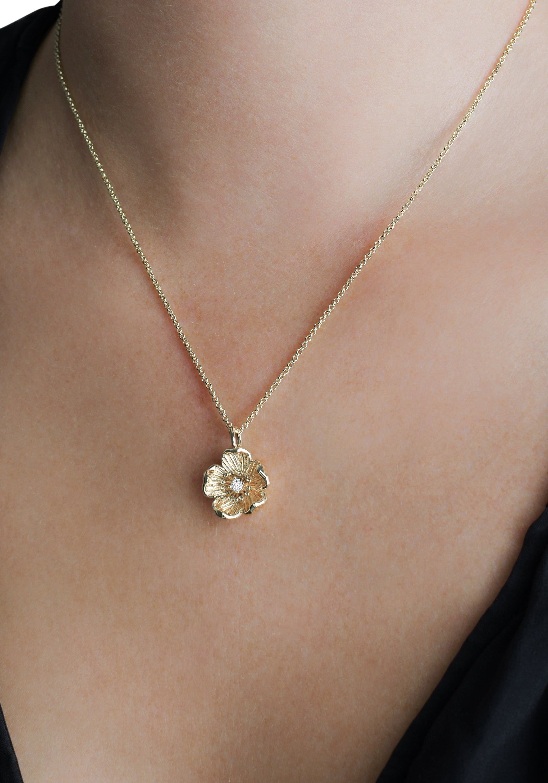 The Anabel Aram Wildflowers Pendant Necklace, dipped in 18k gold, showcases a textured wildflower pendant that adds an elegant touch against bare skin or dark clothing.