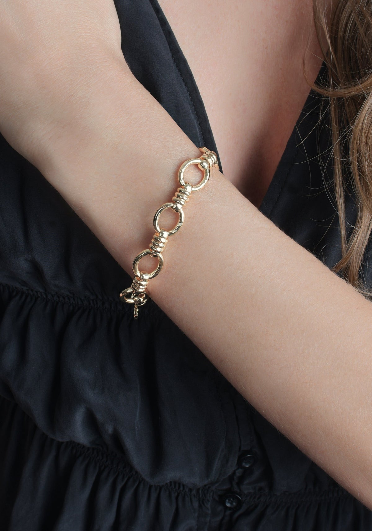 Gold-tone Anabel Aram Neptune Chain Bracelet featuring alternating smooth and textured circular links on a person’s wrist.