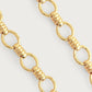 Close-up of Anabel Aram’s Neptune Chain Necklace, showcasing round links joined by trios of small 18k gold dipped rings, set against a simple light background.