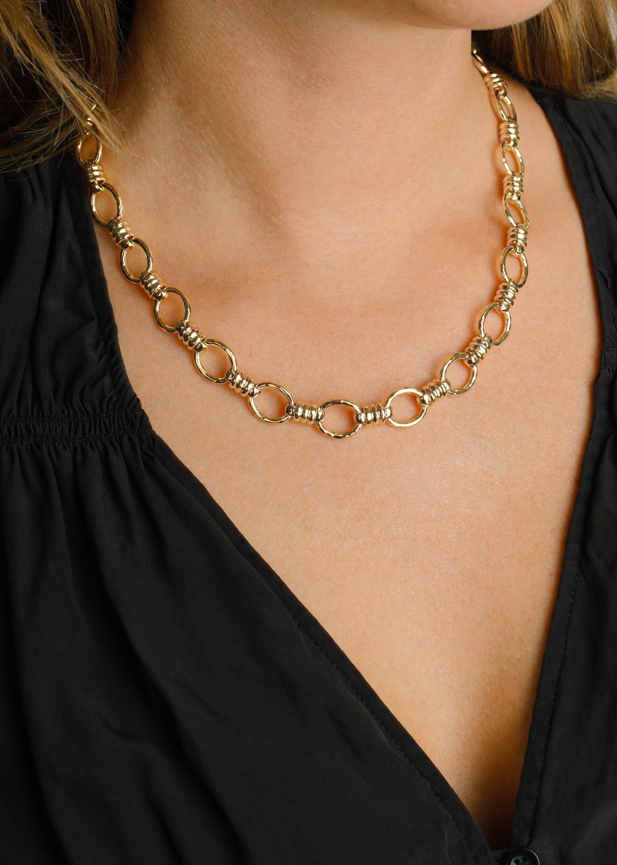 Gold-tone Neptune Chain Necklace featuring interlocking circular links with textured bands and a lobster clasp.