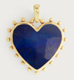 The Heart with Stone Charm by Anabel Aram features a gold heart-shaped pendant, deep blue stone center, gold accents, and beaded detailing along the edges.