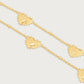 Anabel Aram Heart Station Necklace featuring an 18k gold plated chain with evenly spaced puffy heart charms with beaded edges.