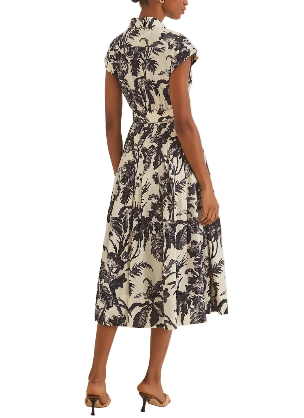 A woman shown from the back wears the Octavia Dress by Cara Cara, featuring a crisp belted design with short sleeves, a collared neckline, and a black-and-white floral midi skirt, paired with beige heeled sandals for a polished look.