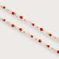 The Milos Beaded Necklace by Anabel Aram features alternating pink, red, white, gold, and turquoise beads, shown against a plain white background.