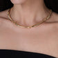 The Milos Fish Necklace is an 18K gold plated statement necklace featuring a series of thin, curved metal links.