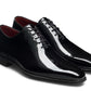 The Magnanni Cruz II Tux Shoes are black patent leather oxfords featuring closed lacing, low heels, and a slightly pointed toe, designed for formal wear with an elegant silhouette.