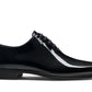 The Magnanni Cruz II Tux Shoes from the Magnanni Core Collection are black patent leather dress shoes designed with a sleek profile, perfect for formal attire. They feature a low heel and lace-up closure.