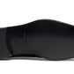The image shows the sole of a black dress shoe from the Magnanni Cruz II Tux Shoes by Magnanni, featuring a smooth leather bottom with small metal details near the heel and the stamp "Made in Italy" embossed on the arch. Perfect for formal attire, this shoe exemplifies understated elegance.
