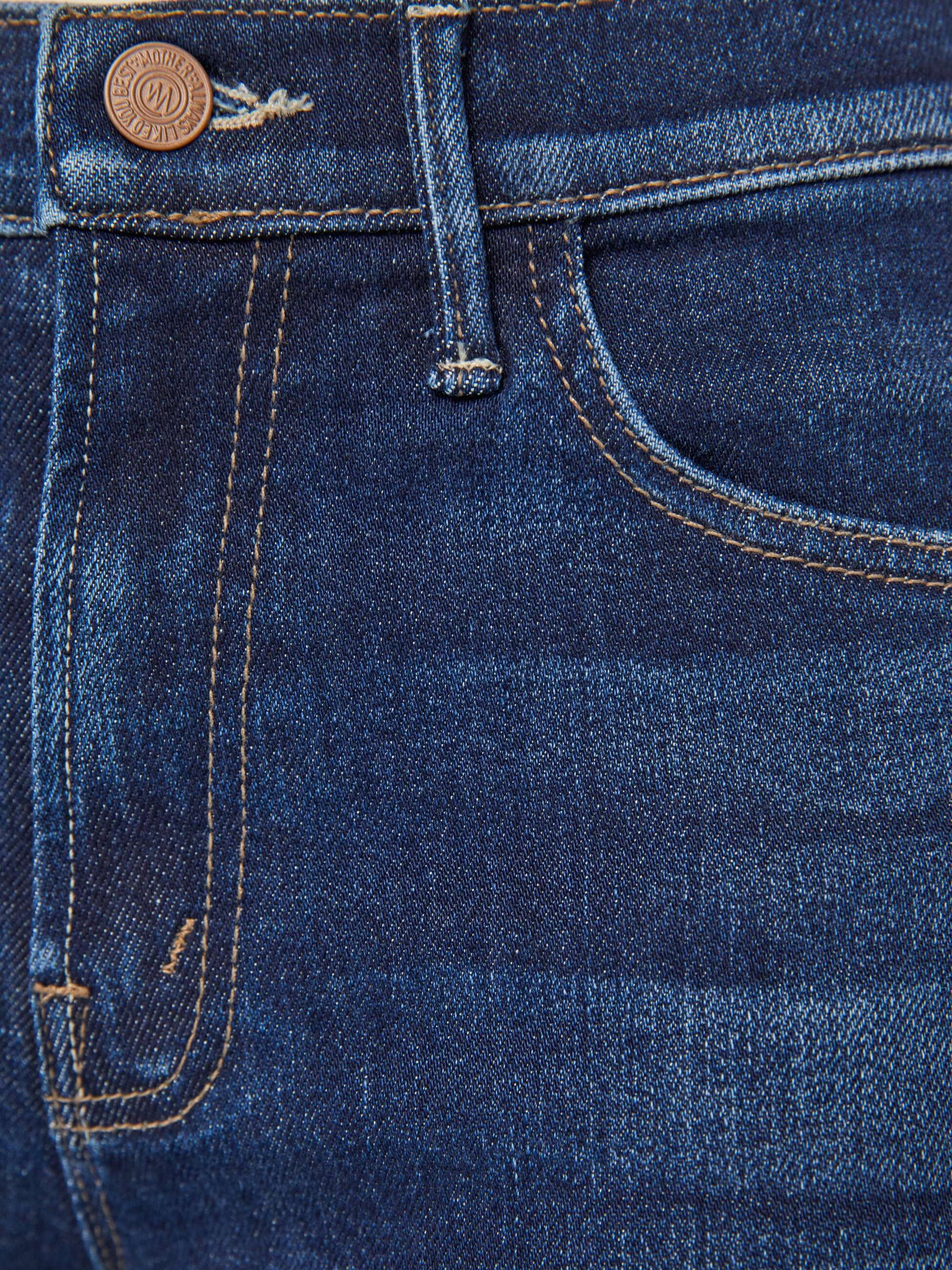 Close-up of the Mother Denim The Insider Ankle in dark-blue wash, highlighting a pocket, belt loop, and bronze button.