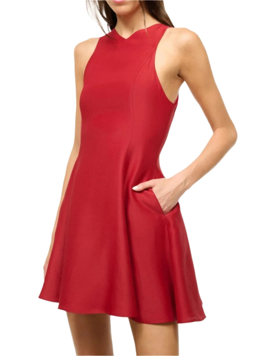 A woman is wearing a stunning Staud Mini Heike Dress in red, featuring a sleeveless design with a fitted waist and a beautifully full-flared skirt, her hands comfortably nestled in the pockets.