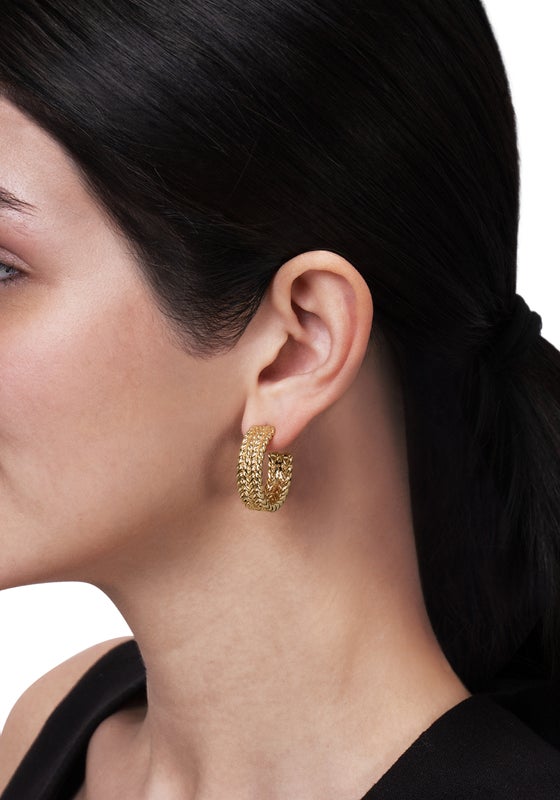 Small 18K gold plated Cheval Braided Hoop Earring worn in an earlobe.