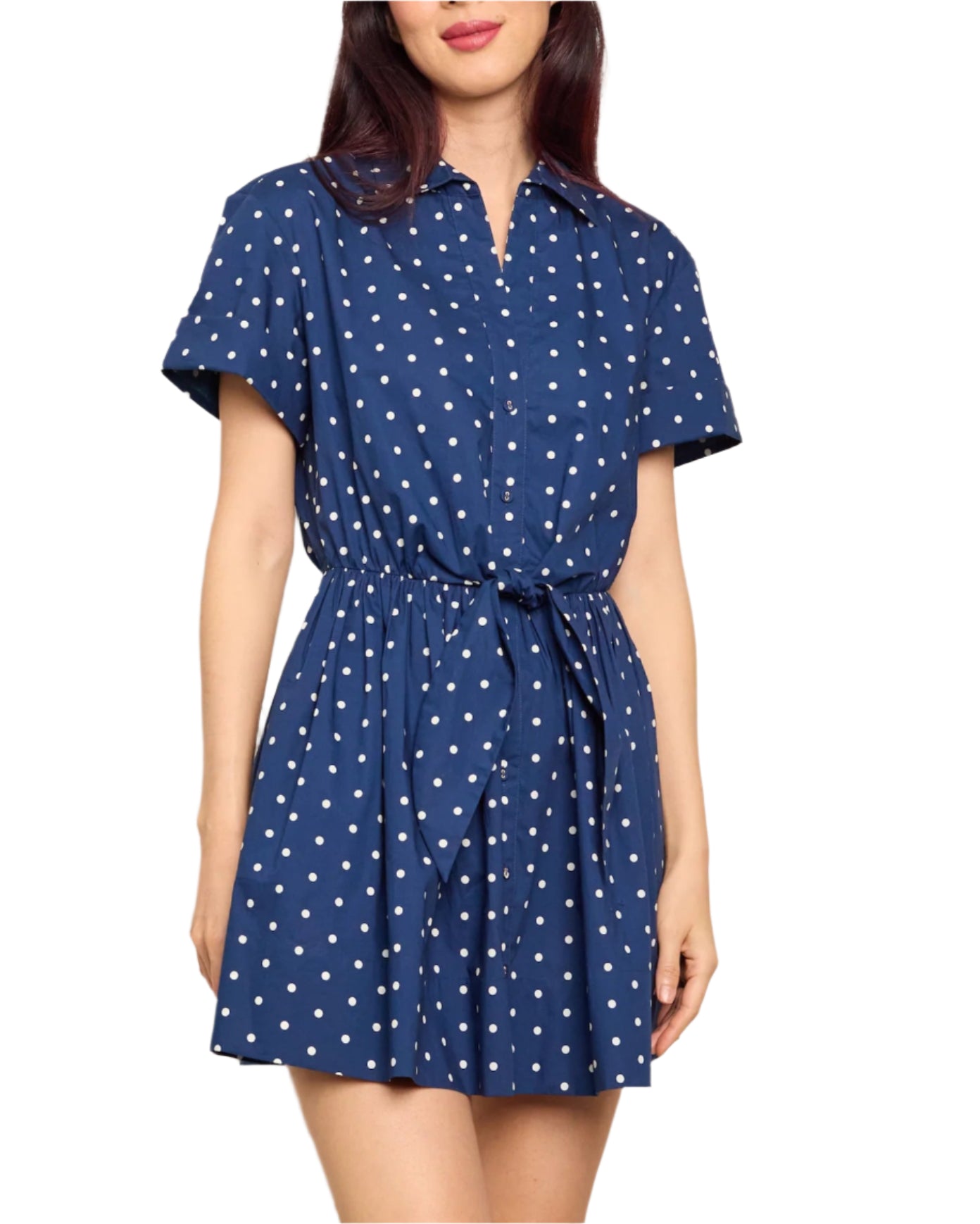 A woman wears the Cara Cara Asbury Dots Mini Dress, featuring short sleeves, blue fabric with white polka dots, a button-down front, and a self-tie waist.