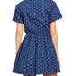 Person wears the Cara Cara Asbury Dots Mini Dress, a short-sleeved, navy blue mini dress with white polka dots and a self-tie waist for a cinched silhouette. Its flared skirt adds charm to this popular style, viewed from the back.