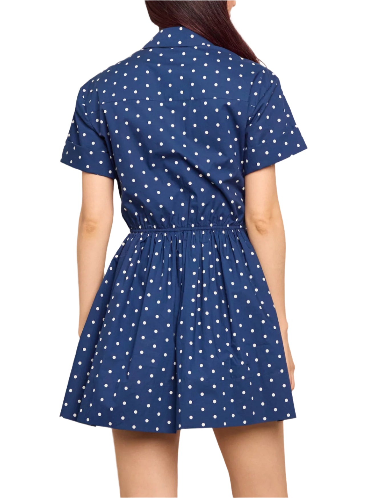 Person wears the Cara Cara Asbury Dots Mini Dress, a short-sleeved, navy blue mini dress with white polka dots and a self-tie waist for a cinched silhouette. Its flared skirt adds charm to this popular style, viewed from the back.