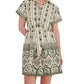 A woman wears the Cara Cara Asbury Mini Dress, a green and cream shirtdress with a placed print, short sleeves, collared button-down front, and matching tie waist.