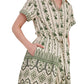 A woman wears the Cara Cara Asbury Mini Dress, a short-sleeve collared shirtdress featuring a green and cream placed print, button front, waist tie detail, and side pockets.