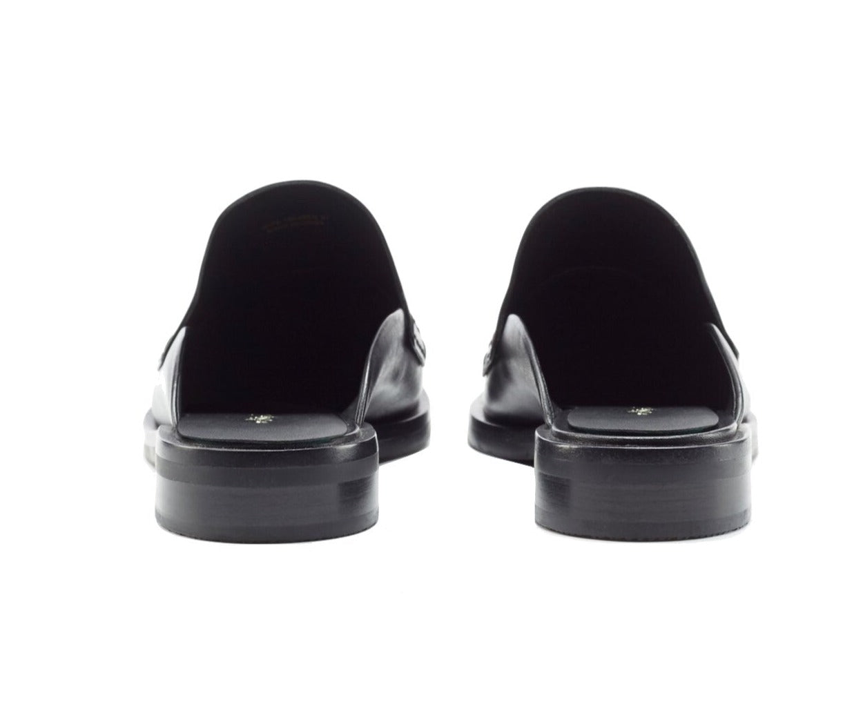 Rear view of a pair of 3.1 Phillip Lim Alexa Loafer Mules in smooth black calf leather, featuring a low heel and backless slip-on design, shown against a plain white background.