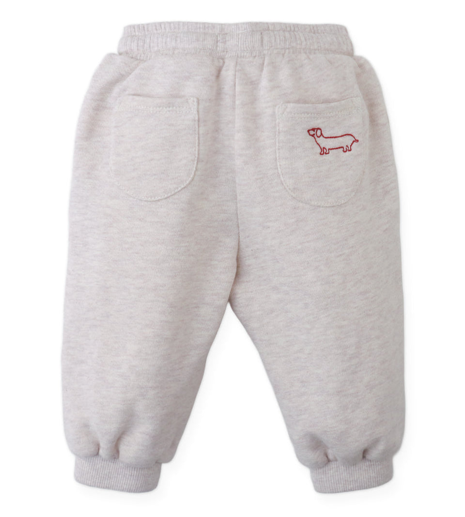 Gingersnaps Baby Boys’ Alessio French Terry Jogger Pants are light gray toddler sweatpants made from soft French terry fabric, featuring an elastic waistband and cuffs for comfort. These cozy joggers have two back pockets and a small red dog outline embroidered on the right pocket.
