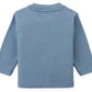 The Baby Boys’ Myron Graphic Tee by Gingersnaps is displayed laid flat with the back side facing up, showing its plain light blue color and long sleeves.