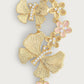 Anabel Aram’s Butterfly with Flowers Dangle Earrings feature a cascading gold-tone design with textured flowers, pink accents, and rhinestones.