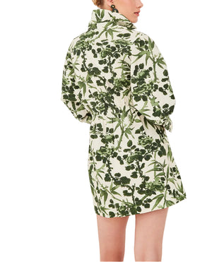 A woman wears the Henry Dress by Cara Cara, a green and white button-down mini dress featuring oversized cuffed sleeves.
