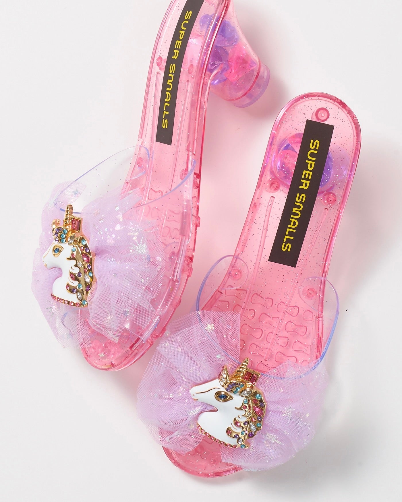 Unicorn Wishes Playshoes by Super Smalls: pink translucent dress-up heels with glittery tulle bows and unicorn head accents—perfect for magical adventures.