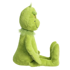 A side view of an Aurora Dr. Seuss Grinch, Jumbo plush toy is shown sitting upright with legs extended and arms at its sides, set against a white background.