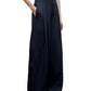 Model wearing the TWP Drew Coated Viscose Linen Pant in navy, featuring a high-rise wide leg silhouette with pockets, paired with a light grey sleeveless top. Image shown from shoulders to feet.