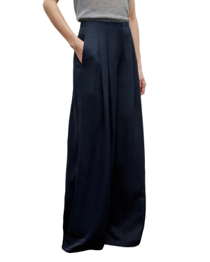 Model wearing the TWP Drew Coated Viscose Linen Pant in navy, featuring a high-rise wide leg silhouette with pockets, paired with a light grey sleeveless top. Image shown from shoulders to feet.