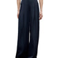 A person wears the TWP Drew Coated Viscose Linen Pant, featuring a high-rise wide leg fit with front pleats, paired with a light grey top.