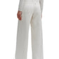 Shown from the back, a person wears TWP’s Almost Famous Pant—relaxed fit, wide leg, off-white cotton linen denim with two back pockets—paired with a light sweater and black flats for an effortlessly chic look.