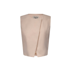 The High Neck Hidden Placket Vest by TWP is a sleeveless, light beige piece in a viscose linen blend, featuring a minimalist design and asymmetrical front opening. The TWP label appears inside the collar.