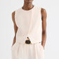 A person wears the TWP High Neck Hidden Placket Vest in sleeveless light beige, paired with matching high-waisted pants made from coated viscose linen, standing against a plain white background.