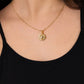 A woman wearing a black top and the Anabel Aram Milos Soleil Charm, a striking gold sunburst necklace inspired by the Mediterranean sun.