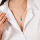A woman wearing a white button-up shirt and the Anabel Aram Milos Stone Drop Charm necklace in turquoise.