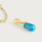 The Anabel Aram Milos Stone Drop Charm features a detachable teardrop-shaped turquoise stone with intricate gold detailing, perfect for adding to your favorite gold chain necklace.