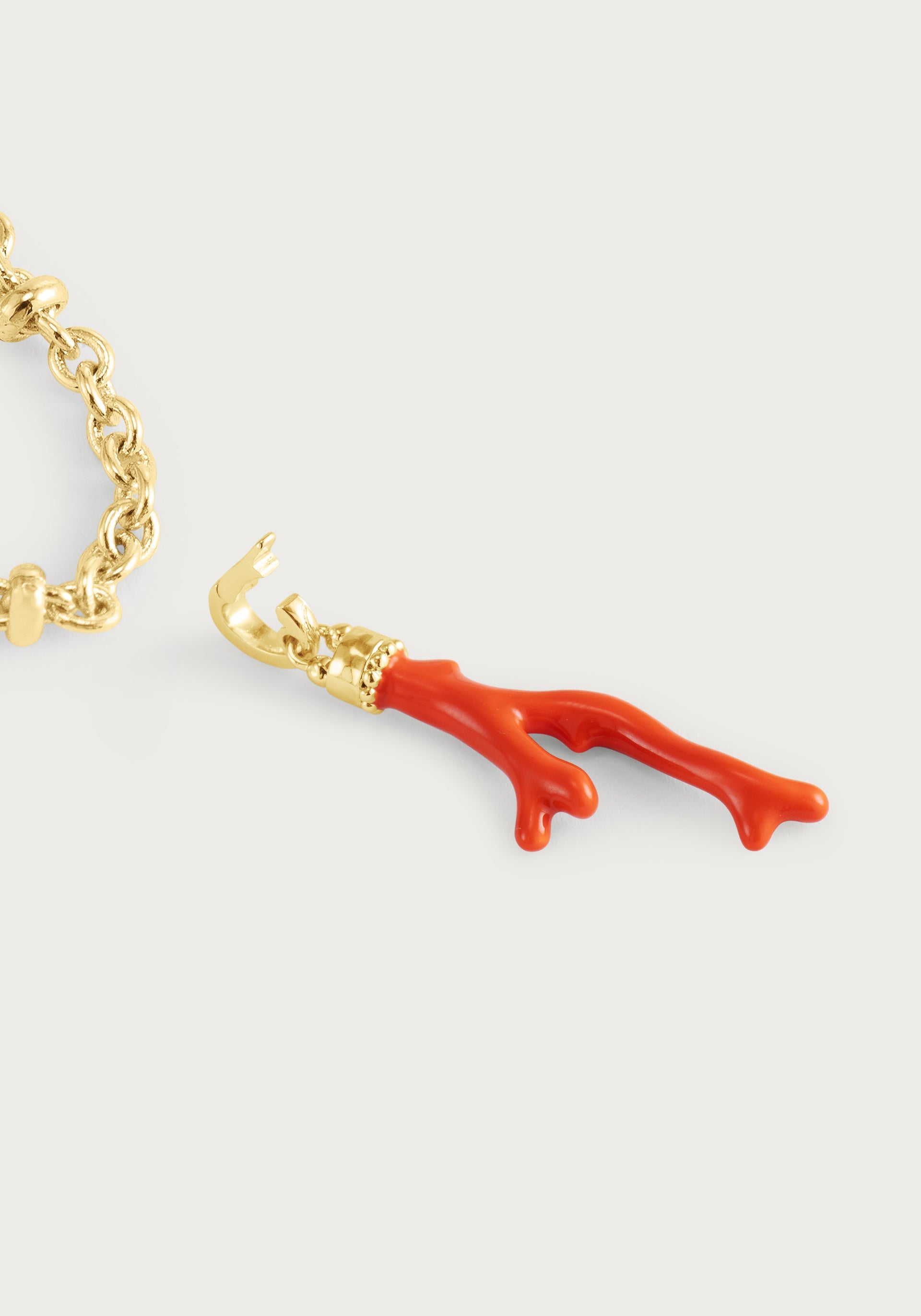 The Anabel Aram Milos Coral Charm bracelet features an 18k gold plated chain with a hand-painted enamel coral pendant, shown on a plain white background.