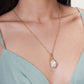 An 18K gold-plated Milos Octopus Charm necklace featuring an octopus holding a baroque pearl pendant.