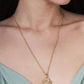 Anabel Aram Milos Shell Locket Charm, a gold-plated shell locket necklace on a chain featuring small, colorful gemstone accents.