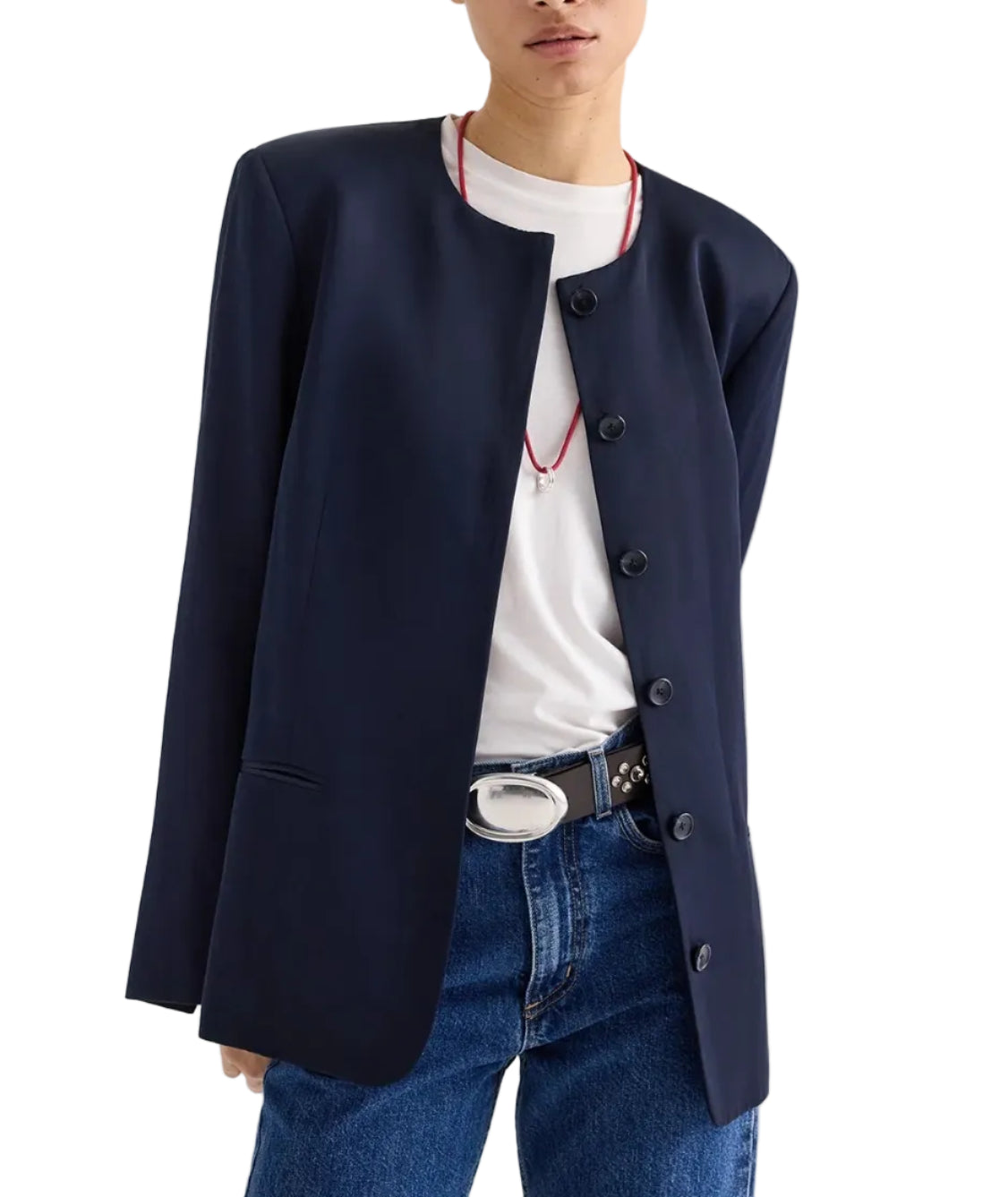 A person wears the TWP Cecelia Coated Viscose Linen Jacket in navy blue over a white t-shirt, blue jeans, a black belt with a silver buckle, and a red necklace.