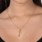 A person wearing the Anabel Aram Tennis Racket Charm gold plated necklace, shown from the shoulders up against a plain background.