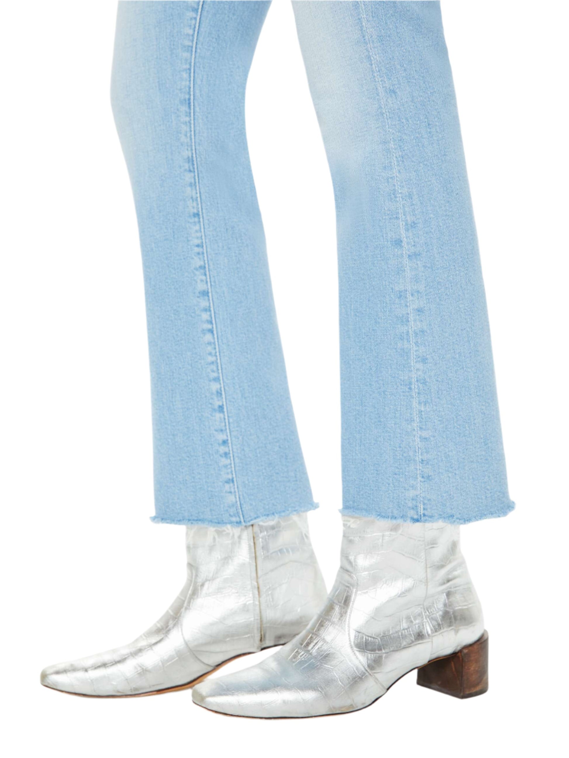 A person styled in Mother Denim The Insider Ankle Fray by Mother, paired with silver ankle boots featuring a block heel.