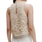 A woman is shown from the back wearing the TWP Shell Silk Organza Fishscales Top, featuring a loose fit with hand-sewn scallops, paired with white pants.